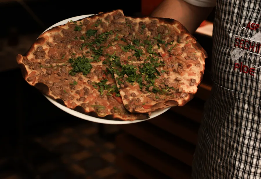 Asp Seçkin önlüklü usta, tabakta sıcak lahmacun servis ediyor